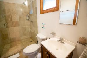 y baño con aseo, lavabo y ducha. en Hotel Ak'Na Holbox en Holbox Island