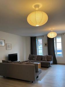 Braine的住宿－Résidence Brainoise 3，客厅配有两张沙发和两个吊灯。