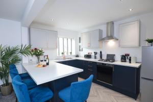 a kitchen with blue and white appliances and blue chairs at Perfect for Contractors with on site parking in Brettell Lane