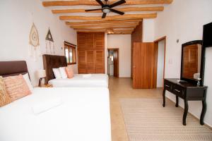 1 dormitorio con 2 camas y ventilador de techo en Hotel Ak'Na Holbox en Holbox Island