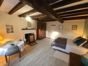 Zimmer mit einem Bett, einem Tisch und einem Kamin in der Unterkunft Guestroom Nohant-Vic, 1 pièce, 2 personnes - FR-1-591-391 in Nohant-Vic