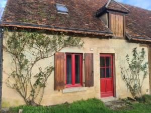 ein Haus mit roten Türen und einem braunen Dach in der Unterkunft Guestroom Nohant-Vic, 1 pièce, 2 personnes - FR-1-591-391 in Nohant-Vic