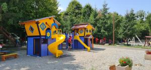 a playground with two play structures with a slide at Complex Pastravaria Albota in Arpaşu de Sus