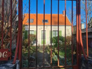 un bâtiment avec un toit orange derrière une porte dans l'établissement Guestroom Châteauroux, 2 pièces, 4 personnes - FR-1-591-396, à Châteauroux