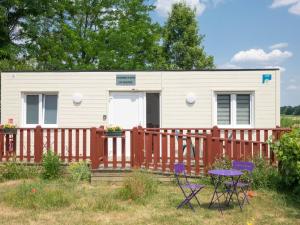 a tiny house with a fence and a table and chairs at Guestroom Noyers, 1 pièce, 2 personnes - FR-1-590-266 in Noyers