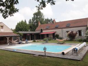 a swimming pool with a hammock and a house at Chambre familiale au cœur de la nature avec jardin et piscine privée, idéale pour explorer le Loiret - FR-1-590-265 in Vitry-aux-Loges