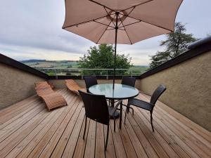 a patio with a table and chairs and an umbrella at Charme du XVIIe siècle près de Nancy, jardin privé et sentiers balisés - FR-1-584-194 in Bouxières-aux-Chênes