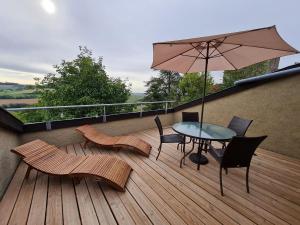 un patio con mesa, sillas y sombrilla en Guestroom Bouxières-aux-Chênes, 1 pièce, 4 personnes - FR-1-584-194 