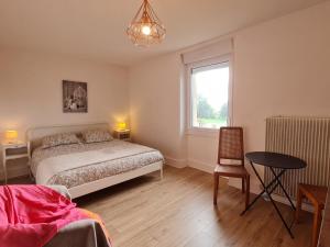 1 dormitorio con cama, mesa y ventana en Guestroom Richecourt, 2 pièces, 4 personnes - FR-1-585-94, 