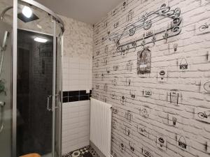ein Bad mit einer Dusche und einer Fliesenwand in der Unterkunft Échappée Relaxante en Famille près du Lac de Madine - FR-1-585-94 in Richecourt + 13 Fotos