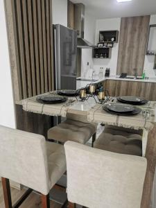 a kitchen with a table with chairs and a counter top at Oak Sky Apartment Spa & Fitness in Skopje +12 photos