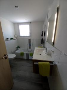 a bathroom with a sink and a tub and a toilet at Haus Fernsicht Wohnung Bergpanorama in Höchenschwand