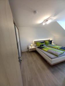 1 dormitorio con 1 cama grande con almohadas verdes en Haus Fernsicht Wohnung Bergpanorama en Höchenschwand