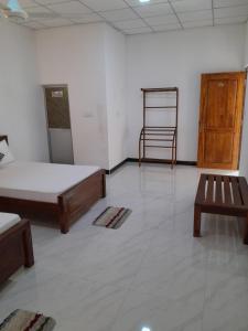 a room with two beds and a chair in it at Sisila Guest House in Anuradhapura