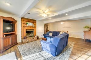a living room with a blue couch and a tv at Charming Emporia Home with Deck and Patio! in Emporia