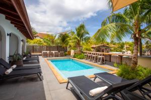 una piscina con tumbonas junto a una casa en Atlantis Beach House, en Willemstad
