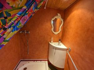 ein Badezimmer mit Toilette, Waschbecken und Spiegel in der Unterkunft Séjour insolite en roulotte cosy avec tout confort près d'Épinal - FR-1-589-459 in Sercoeur