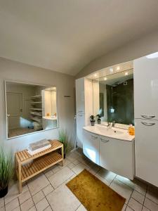 een badkamer met een bad, een wastafel en een bank bij Au Coeur Des Collines, Chouette in Ellezelles