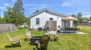 a yard with chairs and a table with an umbrella at Renovated kitchen less than 2 miles to Beach! in Harwich