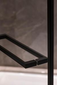 a black glass shelf in front of a window at Umiltà 36 in Rome