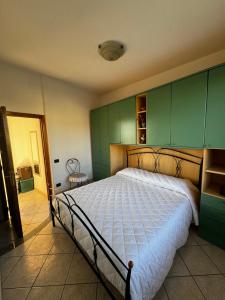 - une chambre avec un grand lit et des armoires vertes dans l'établissement Mandras 2, à La Caletta