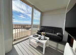 ein Wohnzimmer mit einem Sofa und Meerblick in der Unterkunft Studio magnifique vue mer et port in Valras-Plage