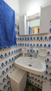 a bathroom with a sink and a blue towel at Small House for Holidays in Leonidio