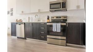 a kitchen with a stove and a microwave at Stunning Nulu 1BR CozySuites Unit 03 in Louisville