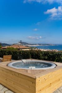 a hot tub in a deck with a view of the ocean at Driftwood Holiday Home in Argassi