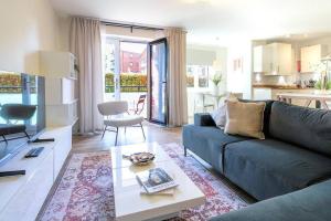 a living room with a couch and a table at Exquisite Apartment with Balcony, Free Parking, Fast WiFi, and Smart TV by Yoko Property in Milton Keynes