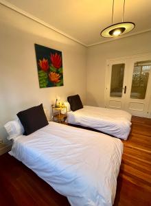 dos camas sentadas una al lado de la otra en una habitación en City Central By Sleep In Bilbao en Bilbao