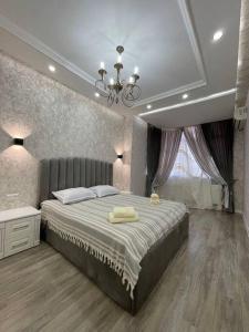 een slaapkamer met een groot bed en een kroonluchter bij City Plaza Zebo in Samarkand