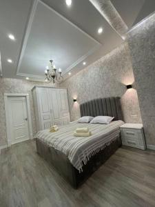 a bedroom with a large bed with two towels on it at City Plaza Zebo in Samarkand