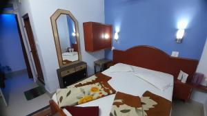 a small bedroom with a bed and a mirror at Hotel swapanlok, Couple Friendly Hotel in Muzaffarpur