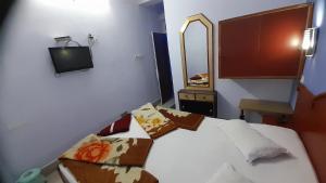 a bedroom with a bed and a tv on the wall at Hotel swapanlok, Couple Friendly Hotel in Muzaffarpur