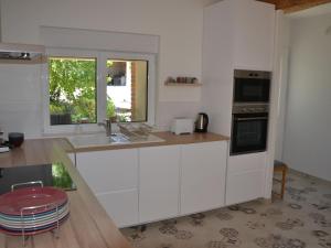 eine Küche mit weißen Schränken, einem Waschbecken und einem Fenster in der Unterkunft Gîte Chilleurs-aux-Bois, 2 pièces, 2 personnes - FR-1-590-276 in Chilleurs-aux-Bois