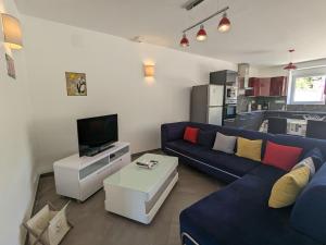uma sala de estar com um sofá azul e uma televisão em Gîte Longeaux, 3 pièces, 6 personnes - FR-1-585-98 em Longeaux