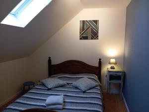 1 dormitorio con 1 cama en un ático con ventana en Maison de pécheur a Barfleur, en Barfleur