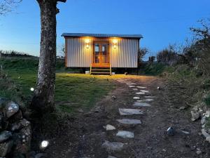 a small cabin with a tree and a walkway at The Hut@Trefechan Wen - Coastal Coziness! in Goodwick