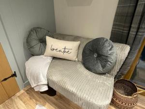 a couch with a pillow on it in a room at The Hut@Trefechan Wen - Coastal Coziness! in Goodwick