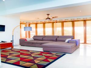 een woonkamer met een bank en een tapijt bij One bedroom appartement at Au cap 100 m away from the beach with enclosed garden and wifi in Au Cap