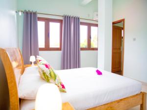 a bedroom with two beds and two windows at One bedroom appartement at Au cap 100 m away from the beach with enclosed garden and wifi in Au Cap