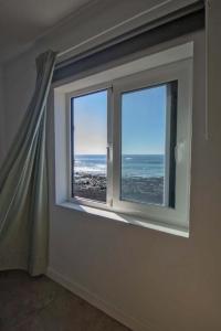 a window in a room with a view of the ocean at Apartamento Valeron in El Golfo