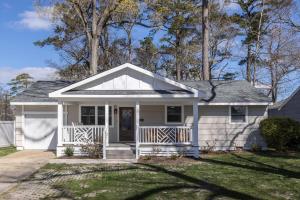 a small white house with a porch at The Beach Vibe with Hot tub 8 min to the Beach in Virginia Beach