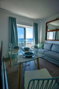 Apartamento Valeron في إل جولفو: غرفة معيشة مع طاولة وإطلالة على المحيط