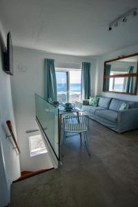 uma sala de estar com uma mesa de vidro e um sofá em Apartamento Valeron em El Golfo