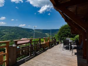 a wooden deck with a view of the mountains at Chalet ensoleillé dans les Hautes Vosges avec terrasse, local vélos et skis, charges incluses - FR-1-589-486 in Thiéfosse +28 photos