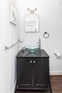 a bathroom with a glass sink on a black cabinet at The Hammock House in Virginia Beach