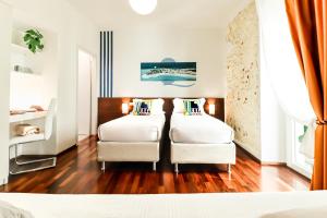 a bedroom with two beds and two chairs at B&B Qaral in Cagliari