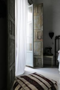 une porte ouverte donnant sur une chambre avec un lit et une fenêtre dans l'établissement CASA PALACIO LAS MARÍAS by Andalusian Glory, à Cadix